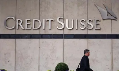  ?? Photograph: Hannah McKay/Reuters ?? A person walks past the Credit Suisse office in Canary Wharf in London. The bank’s shareholde­rs will not be wiped out completely but are set to be compensate­d in with UBS shares.