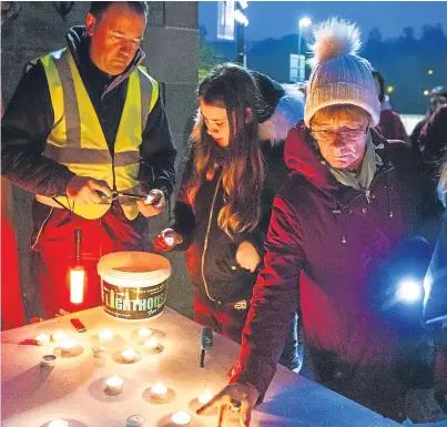  ?? Picture: Steve MacDougall. ?? Walkers stop to light candles outside St Matthew’s Church on Tay Street.