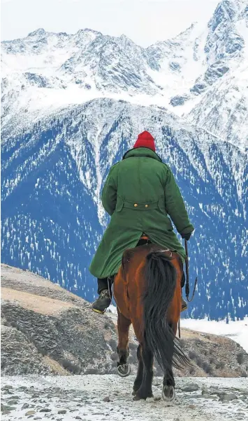  ?? PHOTOS BY HU HUHU / XINHUA ?? A Kazakh herder returns home after grazing sheep and cattle on the pasture in the Akyaz Valley, in Zhaosu county, Xinjiang Uygur autonomous region.