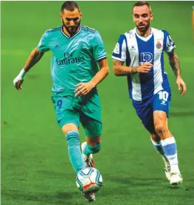  ??  ?? Real Madrid’s Karim Benzema, left, runs past Espanyol’s Sergi Darder during Sunday night’s game in Barcelona. Photo: AP