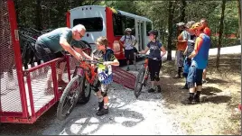  ?? NWA Democrat-Gazette/FLIP PUTTHOFF ?? Riders load bikes on the free shuttle to the top of the downhill trails. The shuttle service is free for the next month or so and operates Thursday through Sunday.