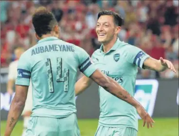  ?? AFP ?? Mesut Ozil (right) celebrates scoring Arsenal’s opening goal against Paris Saintgerma­in with striker Pierreemer­ick Aubameyang.