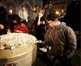  ?? (Photo Dylan Meiffret) ?? Tour à tour, chacun déposait une bougie en hommage aux victimes hier soir devant la basilique.