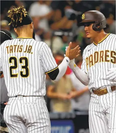  ?? K.C. ALFRED U-T ?? Padres’ Manny Machado celebrates with Fernando Tatis Jr. after hitting a homer in the first inning against the Giants.