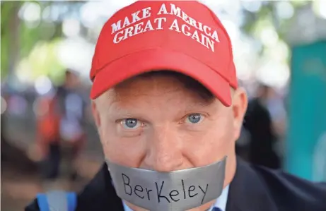  ?? ASSOCIATED PRESS ?? Daryl Tempesta tapes a sign over his mouth in protest during a demonstrat­ion in April in Berkeley, Calif. Demonstrat­ors gathered near the University of California, Berkeley campus amid a strong police presence and rallied to show support for free speech and condemn the views of Ann Coulter.