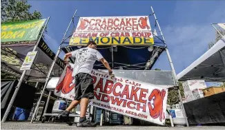  ?? JOHN SPINK / JSPINK@AJC.COM ?? Maciej Morski of Delaware prepares his Crabcake Sandwich venue Friday for the 82nd Annual Atlanta Dogwood Festival running now through Sunday at Piedmont Park.
