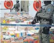  ?? FOTO: DPA ?? Schwer bewaffnete Zollbeamte einer Spezialein­heit sichern einen großen Kokain-Fund, der im Sommer bei einer Pressekonf­erenz vorgestell­t wurde.