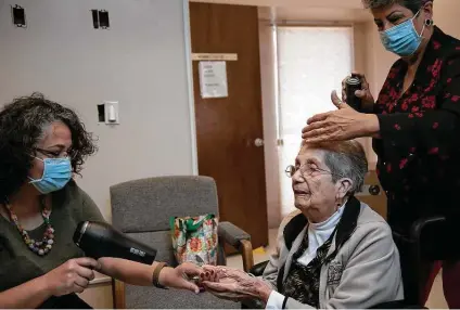  ?? Lisa Krantz / Staff photograph­er ?? Mary Moreno, 91, gets pampered by granddaugh­ter Lori Rodriguez-padilla, who uses a hair dryer to warm her hands, and daughter Helen Rodriguez, who styles her hair during a visit last week at the Sarah Roberts French Home.