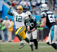  ??  ?? Green Bay Packers’ Aaron Rodgers (left) scrambles against the Carolina Panthers during the first half of an NFL football game in Charlotte, N.C., on Sunday. AP PHOTO