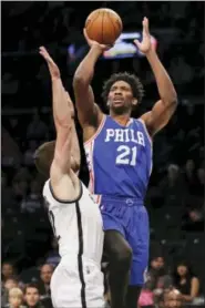  ?? SETH WENIG — THE ASSOCIATED PRESS ?? Philadelph­ia 76ers’ Joel Embiid, right, shoots over Brooklyn Nets’ Joe Harris during the first half of the NBA basketball game at the Barclays Center, Sunday, Jan. 8, 2017, in New York.