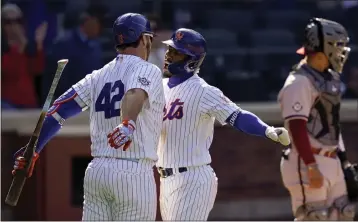  ?? JOHN MINCHILLO — THE ASSOCIATED PRESS ?? The Mets' Francisco Lindor, center, celebrates with Pete Alonso, left, after hitting a solo home run off Diamondbac­ks relief pitcher Caleb Smith in the eighth inning on Friday in New York.