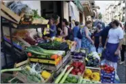  ?? CAIN BURDEAU VIA AP ?? This Aug. 4, 2018 photo shows a street scene outside a fruit and vegetable shop in Castelbuon­o, a lively medieval town in the Madonie Mountains in northern Sicily. The Madonie are a world apart from Sicily’s packed summertime beaches and busy coastlines. This wild region of Sicily is known for its towns atop hills and mountains, its delicious food, ornate churches and friendly people.