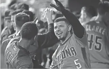  ??  ?? The Diamondbac­ks’ Eduardo Escobar (5) celebrates his home run with Jarrod Dyson during the fourth inning against the Phillies in Philadelph­ia on Monday night. Escobar finished with two homers in the game.