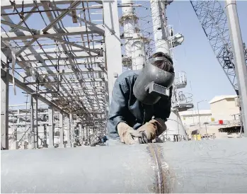  ?? MAJID SAEEDI/GETTY IMAGES ?? A welder works on a section of Iran’s controvers­ial heavy water production facility, at Arak, south of Tehran. The preliminar­y agreement commits Iran to redesign its nearly-built reactor at the facility.