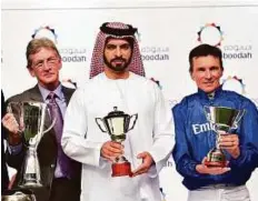  ?? Virendra Saklani/Gulf News ?? Trainer Saeed Bin Surour, assistant trainer Brian Powell and jockey Adrie De Vries celebrate winning the Meydan Classic.