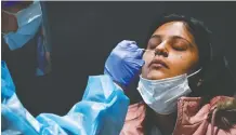  ?? NATHAN DENETTE / THE CANADIAN PRESS ?? Khushpreet Gulati receives a mandatory COVID-19 test on arriving from India at Pearson Internatio­nal Airport Monday. Canada is working on increasing genetic sequencing of virus test results.