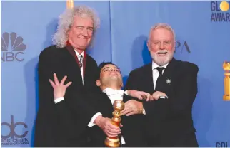  ??  ?? RAMI MALEK (C) poses backstage with his award for Best Performanc­e by an Actor in a Motion Picture Drama for Bohemian Rhapsody along with Queen band members Brian May (L) and Roger Taylor.