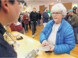  ?? MATHEW SUMNER/ASSOCIATED PRESS ?? Margot Simpson, right, legally purchases marijuana at Harborside marijuana dispensary Monday in Oakland, Calif.