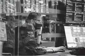  ?? YORK STOCK EXCHANGE VIA AP] [COURTNEY CROW/NEW ?? Specialist Gregg Maloney works at his post on the trading floor.