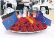  ??  ?? Rote Nelken, Europa-Fähnchen und Deutschlan­d-Flagge als Dekoration.