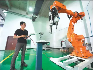  ?? XINHUA ?? A startup entreprene­ur tests a robot at an innovation center in Langfang, Hebei province.