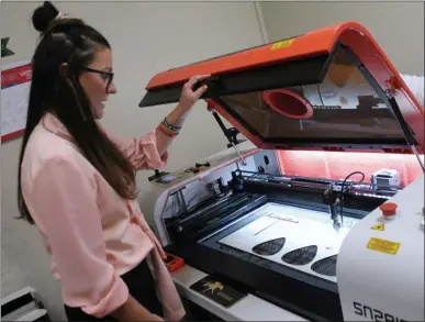  ?? LAUREN HALLIGAN - MEDIANEWS GROUP ?? Saratoga Custom Engraving owner Amanda VanPelt uses the shop’s laser engraver.