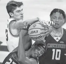  ?? TORK MASON / USA TODAY NETWORKWIS­CONSIN ?? UWGB’s Marcus Hall and UWM’s Faizon Fields (22) fight for a rebound during the quarterfinals of the Horizon League tournament last Thursday at the Kress Center in Green Bay.