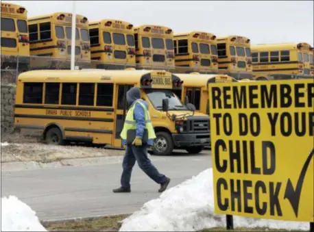  ?? NATI HARNIK — THE ASSOCIATED PRESS ?? In this photo, a driver walks away from the school bus parking lot after his morning shift, in Omaha, Neb. School districts throughout the country are struggling to find school bus drivers, a challenge that has worsened with low unemployme­nt and a strong economy that gives workers a greater choice of jobs.