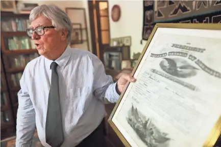  ?? COMMERCIAL APPEAL JOE RONDONE/THE ?? Memphis former attorney and historian George Whitworth talks about some of the items in his collection, including this early 1900's U.S. document signed by President Theodore Roosevelt, at his home Wednesday, Aug 11, 2021.