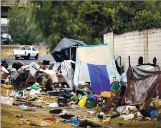  ?? ANDA CHU — STAFF ARCHIVES ?? A vehicle drives past an encampment along the Story Road on-ramp to U.S. Highway 101 in San Jose on Sept. 11. Despite most Bay Area cities agreeing not to remove or “sweep” homeless encampment­s during the pandemic (per CDC recommenda­tions), Caltrans has continued to remove some camps. Caltrans has gotten special permission to dismantle this encampment.