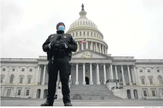  ?? MICHAEL REYNOLDS / EFE ?? Un policía del Capitolio hace guardia ante el edificio con la bandera a media asta por las víctimas del asalto del miércoles.