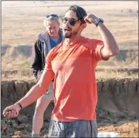  ??  ?? Against the backdrop of a badly eroded piece of land, WWF’s Samir Randera-Rees uses the hair on his head and a handful of soil to illustrate how vegetation can prevent runoff.