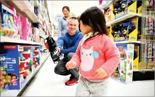  ?? Washington Post photo by Katherine Frey ?? Kaighn Fosmoe, 22 months, runs away as her father, Kris, shows her a Darth Vader toy. The toddler went home with a plush giraffe and two puzzles.