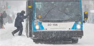  ?? JOHN KENNEY/FILES ?? A woman climbs over a snow bank to board a bus in N.D.G. last winter. Snow tires for buses are not available leaving STM staff to add rubber to existing tires and carve out ridges for better grip.