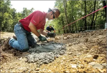  ?? NWA Democrat-Gazette/BEN GOFF • @NWABENGOFF ?? TJ LaPlant (left) and Jeff Cargile with Crossland Constructi­on set footings for a boardwalk Tuesday at Coler Mountain Bike Preserve in Bentonvill­e. Crossland is working on a new trailhead and pavilion on Northwest Third Street and hard-surface greenway through the park connecting to the parking lot on Peach Orchard Road.