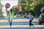  ?? ERIC BONZAR — THE MORNING JOURNAL ?? Crossing guard Theodore Moore helps an Admiral King Elementary School student cross Washington Avenue, on the first day of school, Aug. 23.