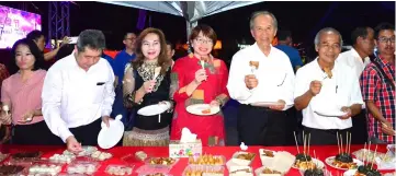  ??  ?? Tiong (third right) and SMC councillor­s try the food at one of the stalls.