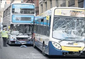  ??  ?? AFTERMATH: Police inspect two buses involved in the incident in Glasgow city centre. Picture: Jamie Simpson