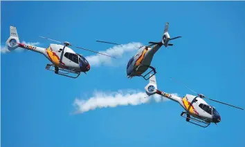  ?? — Reuters ?? Members of the aerobatic patrol of helicopter­s of the Spanish Air Force (Patrulla Aspa) fly over San Lorenzo beach during an aerial exhibition in Gijon, northern Spain, on Sunday.