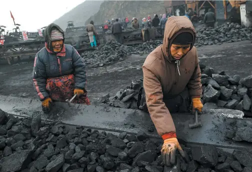  ?? PHOTO AFP ?? Des travailleu­rs trient le charbon sur un tapis roulant près d’une mine à Datong, dans la province chinoise du Shanxi.