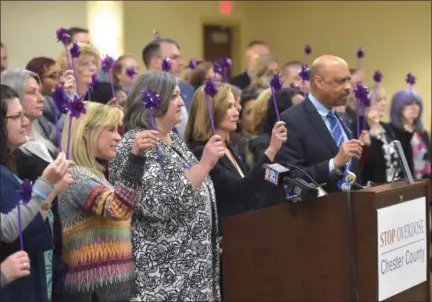  ?? PHOTOS BY PETE BANNAN — DIGITAL FIRST MEDIA ?? Chester County Commission­ers, center, Kathi Cozzone, Michelle Kichline and Terence Farrell, victims’ families and concerned community members and opioid awareness supporters hold purple pinwheels in a tribute to victims of the opioid crisis in Chester County.