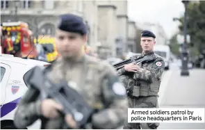  ??  ?? Armed soldiers patrol by police headquarte­rs in Paris