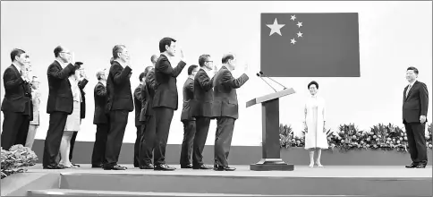  ??  ?? This handout photo by Hong Kong’s Informatio­n Services Department shows Lam (centre) standing with Xi (right) as her ministers (left) are sworn in during a ceremony at the Hong Kong Convention and Exhibition Centre. — AFP photo