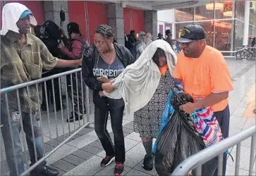  ?? Mark Ralston AFP/Getty Images ?? EVACUEES ARRIVE at a convention center in Houston. As many as 13 million people from Houston to New Orleans were under f lood watches and warnings. President Trump planned to visit south Texas on Tuesday.