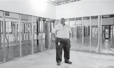  ?? Michael Wyke ?? Library director Anthony McMillan in what used to be his office on the first floor of the library building of the Lone Star College-Kingwood campus, where 95 percent of the books were lost in the flooding.