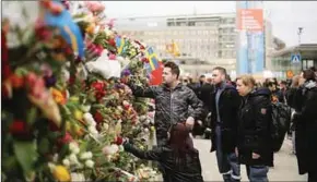  ??  ?? Mensen laten massaal bloemen achter nabij de plek van de aanslag.