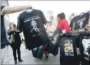  ?? Gary Coronado Los Angeles Times ?? STREET VENDORS pitch Kobe Bryant T-shirts Wednesday outside Staples Center, where memorials for the late basketball star show no signs of slowing.