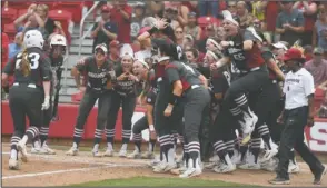  ?? NWA Democrat-Gazette/J.T. Wampler ?? GO AHEAD: Arkansas freshman Hannah McEwen’s teammates meet her at home plate Sunday after her two-run home run in the fourth inning put the Razorbacks up, 5-4, en route to a 6-4 victory in the final of the Fayettevil­le Regional at Bogle Park.