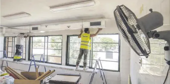  ?? A.J. GONZÁLEZ ?? Unos operarios trabajan en la climatizac­ión de un colegio.