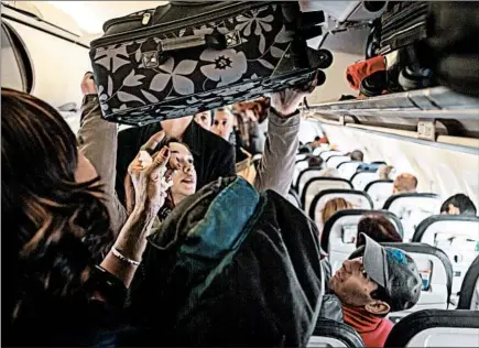  ?? ROBERT NICKELSBER­G/GETTY ?? United passengers who book basic economy fares typically aren’t allowed to bring a full-sized carry-on bag aboard the plane.